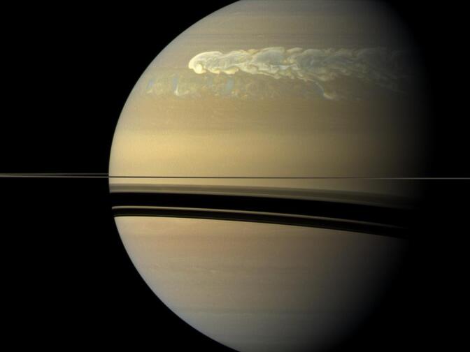 Side view of Saturn as a storm rages across its northern half.