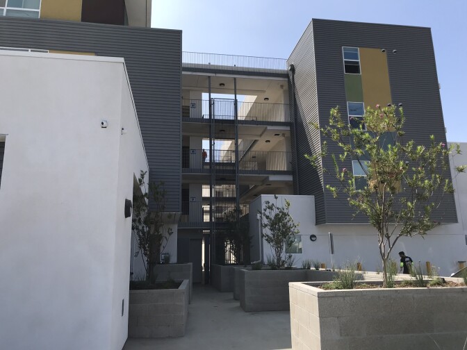 A gray building with an exposed walkway between sections.