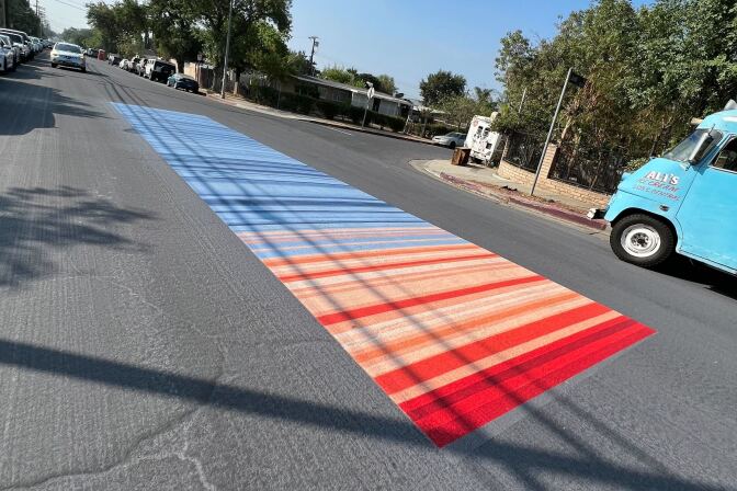 A street painted with bright red and baby blue colors symbolizing a heat scale.