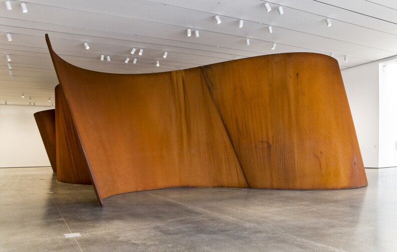 Amber colored sculpture made of sheets of steel.
