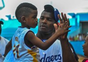 Dodgers player Yasiel Puig holds his nephew during a children's baseball training session in Havana, Cuba on December 16, 2015.