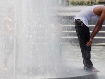 NEW YORK, NY - JULY 18:  A man stands in a fountain in Washington Square Park on July 18, 2012 in New York City. Temperatures were expected in the upper 90's during another heat wave in the city.  (Photo by Mario Tama/Getty Images)