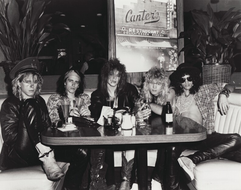 Members of Guns N' Roses sitting at a Canter's Deli booth.