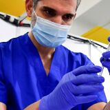 Derenik Gharibian, Area Pharmacy Drector from Kaiser Permanente, fills a syringe with the Pfizer Covid-19 vaccine in preparation for vaccinations on the opening day of a large-scale Covid-19 vaccination site at a parking structure at Cal Poly Pomona University in Pomona, California on February 5, 2021. - The Cal Poly Pomona site is one of two opening in California, with the other located at Moscone Center in San Francisco. According to organizers each site will ultimately have the capacity to administer up to 10,000 vaccine doses per day. (Photo by Frederic J. BROWN / AFP) (Photo by FREDERIC J. BROWN/AFP via Getty Images)