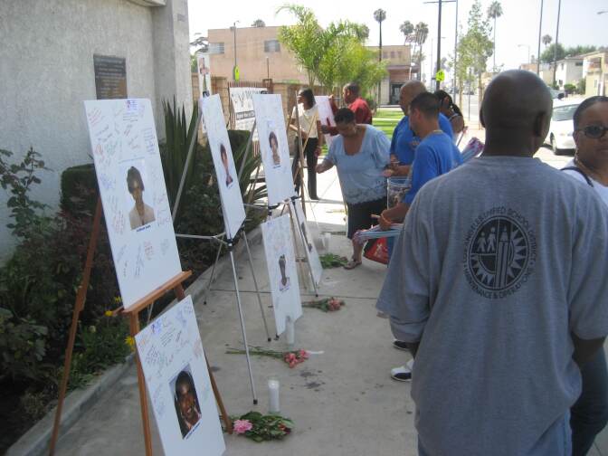 Visitors and passersby write messages on photos of Grim Sleeper victims on display at Bethel AME Church in South Los Angeles