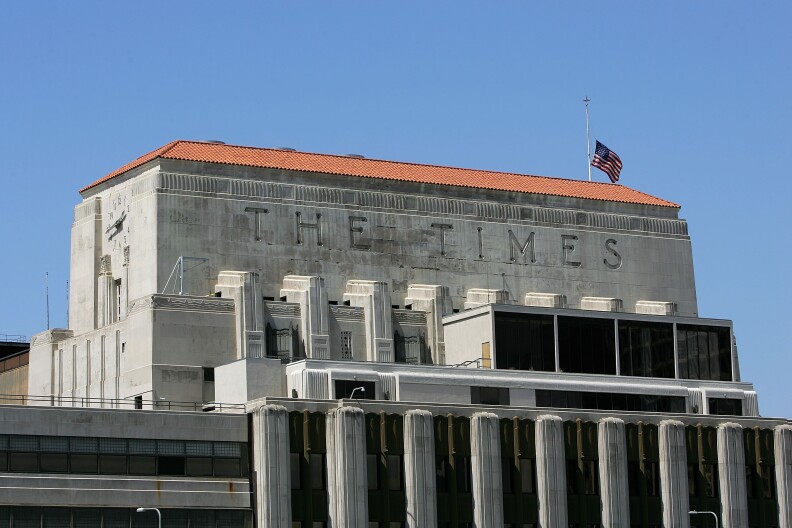 LOS ANGELES - APRIL 23:  A flag flies half-staff on top of the Los Angeles Times building April 23, 2007 in Los Angeles, California. The Times announced today that it will offer voluntary buyouts in an effort to cut its staff of 2,625 by up to 150. Up to about 70 of those jobs would be in the newsroom, dropping the news staff to about 850. When the Tribune Co. bought the newspaper in 2000, there were 1,200 employed on the news side. Last fall, publisher Jeffrey M. Johnson and then Editor Dean Baquet were forced from the paper for fighting against cuts in the newsroom and arguing that a reduction of reporters and editors would hurt the quality of the paper, a belief contrary to that of Tribune executives.  (Photo by David McNew/Getty Images)