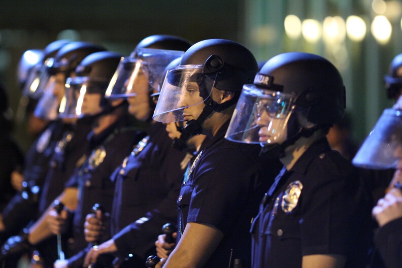 LOS ANGELES, CA - NOVEMBER 25:  Police officers line up to protect the LAPD Headquarters as they face off with protesters after the grand jury decision not to indict a white police officer who had shot dead an unarmed black teenager in Ferguson, Missouri, in the early morning hours of November 25, 2014 in Los Angeles, California. Police officer Darren Wilson shot 18-year-old Michael Brown on August 9, sparking large ongoing protests.  (Photo by David McNew/Getty Images)