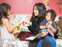 Sara Martín reads bedtime stories with her two kids. She says when the kids were younger, it was difficult to keep them up to date on their vaccination due to transportation and other barriers.