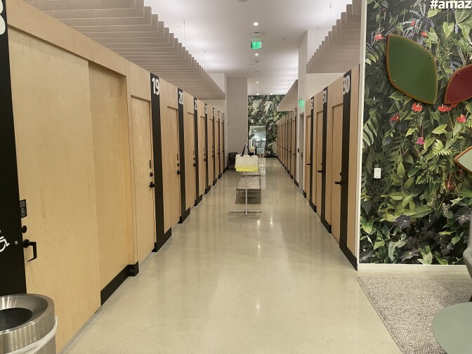 A hallway filled with numbered fitting rooms.