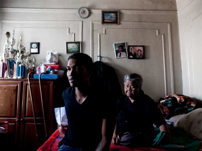 Sovann Ith, 23, sits alongside his grandmother, Somaly Ith, 83, in the living room of their Bronx apartment. The complex was once predominantly Cambodian, but is now home to just five families. Bronx, New York, Sept. 2011.