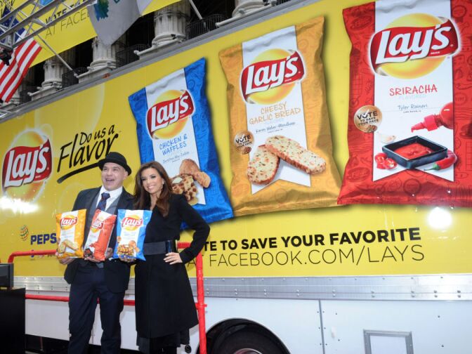 Actress Eva Longoria and Chef Michael Symon join the Lay's brand at the New York Stock Exchange, Tuesday, Feb. 12, 2013, in New York, to introduce the three Lay's "Do Us A Flavor" contest finalist flavors - Lay's Cheesy Garlic Bread, Lay's Chicken & Waffles and Lay's Sriracha flavored potato chips - now available on store shelves nationwide.  