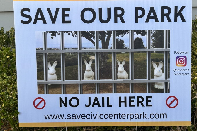 A yard sign reads 'Save Our Park, No Jail Here' with an image of rabbit statues behind bars overlaid on a park photo.