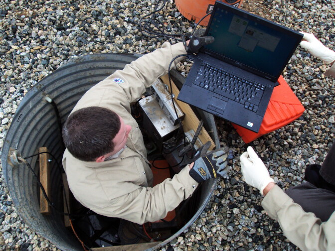 Seismic engineer Josh Sessoms is in vault where a $17,000 motion sensor will sit. He is using a laptop to test the system as he installs the sensor.