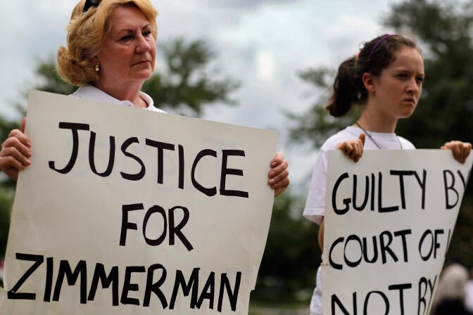 SANFORD, FL - APRIL 21:  Anna Johnson (L) and Faith Sapp hold signs during a small rally that was billed as an opportunity to show  support of the Constitutional Rights for George Zimmerman and Trayvon Martin near the jail where George Zimmerman waits to be released on bond on April 21, 2012 in Sanford, Florida. Zimmerman turned himself in to police in connection with the killing of Trayvon Martin on February 26th while Zimmerman was on neighborhood watch patrol in the gated community of The Retreat at Twin Lakes, Florida.  (Photo by Joe Raedle/Getty Images)