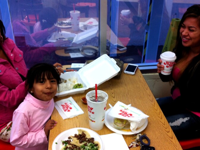 Cousins Antonia and Jocelyn, and youngster, dine at King Taco #1 in Cypress Park. The store closed for a day this week to honor the memory of founder Raul Martinez, Sr.
