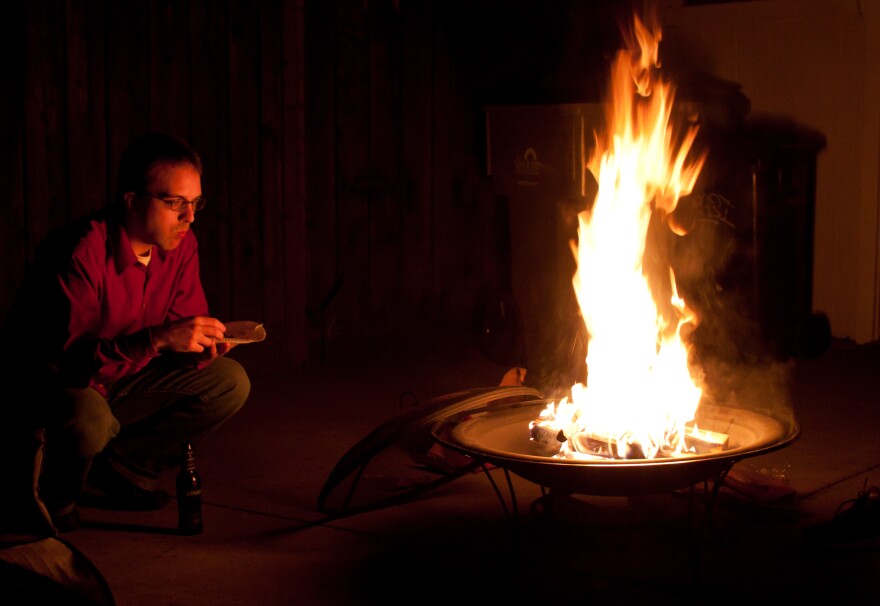 A man sits around a backyard fire pit in San Jose, California. Such outdoor residential burning is prohibited during no-burn days in Southern California.