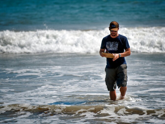 UCSB graduate student Nick Schooler measures wave frequency at a Malibu beach.