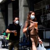 People carry their pints of beer past tables for outdoor dining in Los Angeles, California on July 1, 2020, after indoor restaurants, bars and movie theaters across much of California were ordered to close for at least three weeks. - Some Californian restaurants shut their doors Wednesday as new measures to tackle the coronavirus pandemic threaten to scupper US Independence Day plans, with beaches closed, fireworks displays scrapped and family reunions put on hold. Indoor restaurants, bars and movie theaters across much of California were ordered to close for at least three weeks, in a major reversal of the state's reopening process. (Photo by Frederic J. BROWN / AFP) (Photo by FREDERIC J. BROWN/AFP via Getty Images)