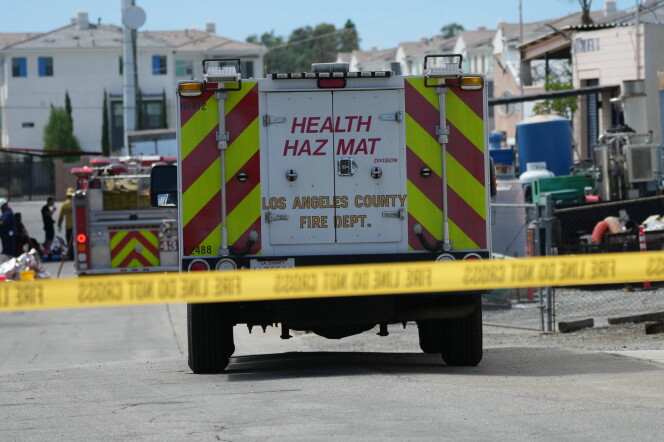Emergency vehicles are parked on a street behind yellow tape.