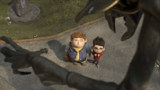 A still from the animated film "Paranorman." It features two young boys staring up at a looming, dark figure with spindly hands and a pincer-like mouth.