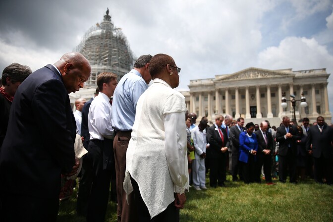 WASHINGTON, DC - JUNE 18: Rep. John Lewis (D-GA) (L) joins members of the US House of Representatives and members of the US Senate in a prayer circle in front of the US Capitol to honor those gunned down last night inside the historic Emanuel African Methodist Episcopal Church in Charleston South Carolina, June 18, 2015 in Washington, DC. Police have arrested Dylann Roof, 21, of Lexington, South Carolina in the shooting that killed 9 people. (Photo by Mark Wilson/Getty Images)