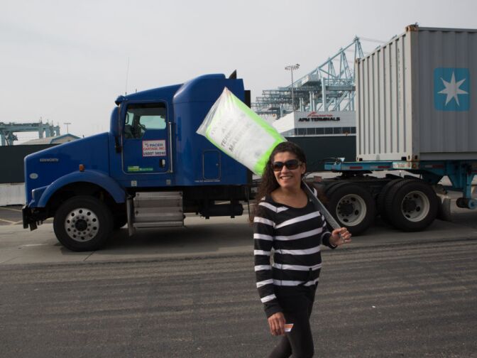 Gina, a clerical worker at the Port of Los Angeles, pickets in front of a truck that cannot enter the APM terminal due to the ongoing strike. L.A. Mayor Antonio Villaraigosa says the strike is costing the local economy billions.