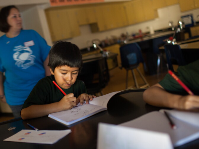 Fourth-grader Bryan Robledo designs a bridge during a summer science camp for that helps homeless children sponsored by Cal State Unversity - Long Beach.