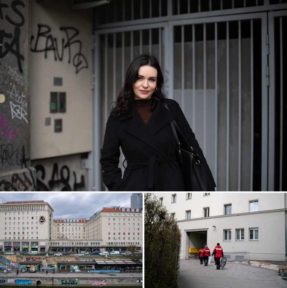 A woman with dark hair poses in front of a building with a metal gate. Below are other buildings.