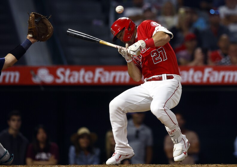Mike Trout #27 of the Los Angeles Angels dodges a pitch that nearly hit his head.