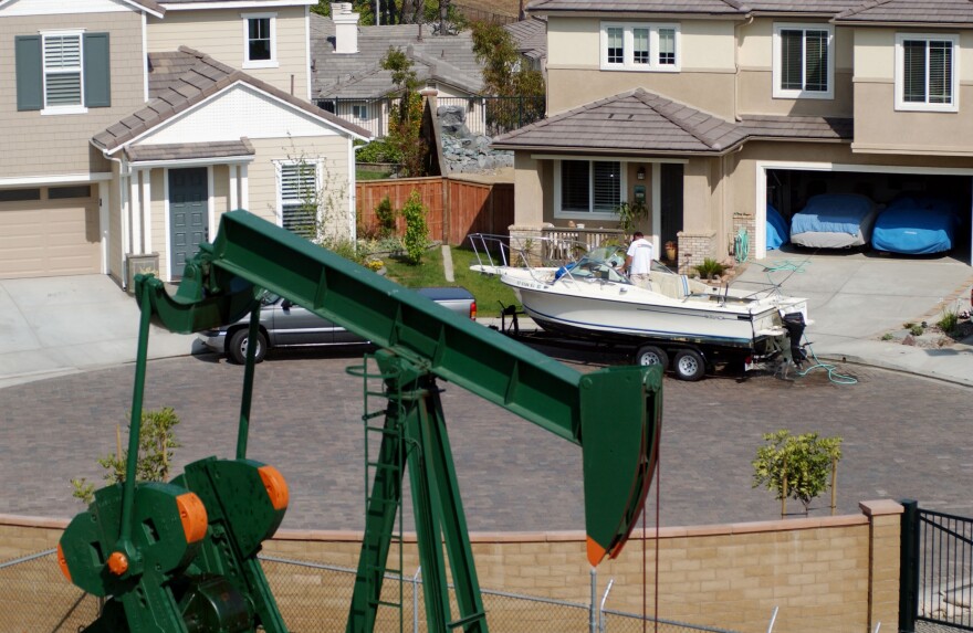 LONG BEACH, CA - MAY 30: An oil well pumps in a newly constructed neighborhood near Shell Oil Company Alamitos No. 1 discovery well on Signal Hill on May 30, 2003 in Long Beach, California. Alamitos No. 1 was created in 1921 and helped establish California as one of the world's major oil-producing states. The Signal Hill Oil Field, now known as the Long Beach Oil Field, reportedly had the world's highest oil production per acre by the mid-twentieth century. Hundreds of companies and individuals became rich on minute leases, some locations so close that derrick legs overlapped. New housing and stores are now being built among operating oil wells. Farther north, a cancer scare has swept over Beverly Hills High School where environmental activist Erin Brockovich and her boss, lawyer Ed Masry, are alleging that toxic fumes from oil wells on the campus have created a "cancer cluster" that is 20 times higher than the national average. (Photo by David McNew/Getty Images)