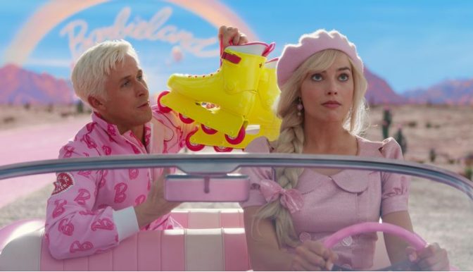 Margot Robbie and Ryan Gosling sit in a pink convertible, driving down a pink road in the middle of the desert with pink mountains behind them. Robbie is driving with Gosling in the back seat. She wears a pink dress with puffy sleeves and a matching pink beret. Her hair is in a long side braid with a pink bow tying it at the end. She looks ahead, slightly annoyed at Gosling who is wearing an all-pink track suit with a Barbie B logo print. He holds up bright, neon roller skates. 