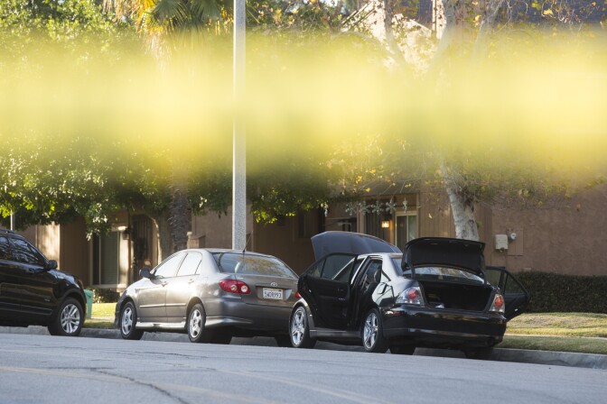 N Center Street between Pine Street and N Center Place remains closed as authorities continue to search a Redlands home on Thursday morning, Dec. 3, 2015 following Wednesday's mass shooting at in San Bernardino. The hood, doors and trunk of a car remain open outside the residence.