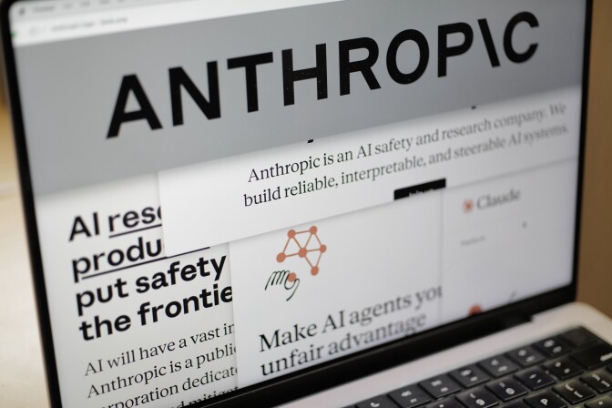 Laptop screen has Anthropic logo and content.