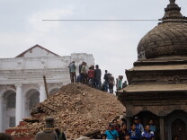 KATHMANDU, NEPAL - APRIL 25 : Local people help with rescue work at the site of a building that collapsed after an earthquake in Kathmandu, April 25, 2015. Hundreds of people have been killed in Nepal after the Himalayan nation was hit by a powerful earthquake Saturday. At least 970 people have been killed in different parts of the country according to figures released by the Nepali Police. (Photo by Sunil Pradhan/Anadolu Agency/Getty Images)