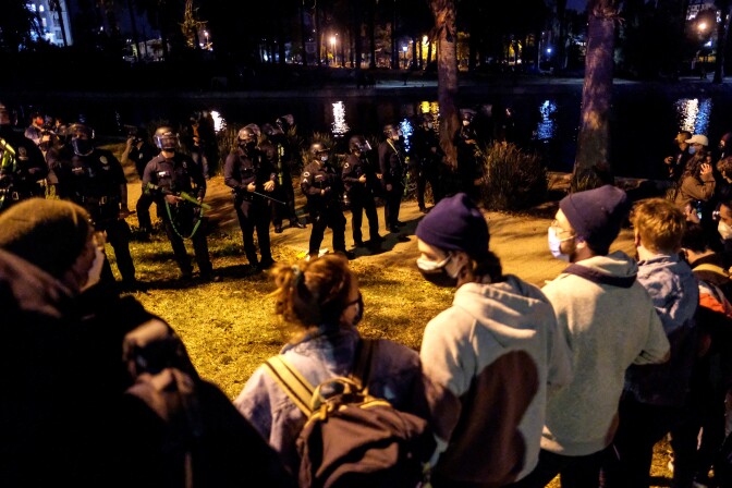 Activists and supporters of residents of a homeless encampment confront police at Echo Park Lake in Los Angeles late on March 24, 2021, ahead of a planned and announced clean-up of the encampment - part of an estimated half-million USD city clean-up and repair effort. (Photo by RINGO CHIU / AFP) (Photo by RINGO CHIU/AFP via Getty Images)