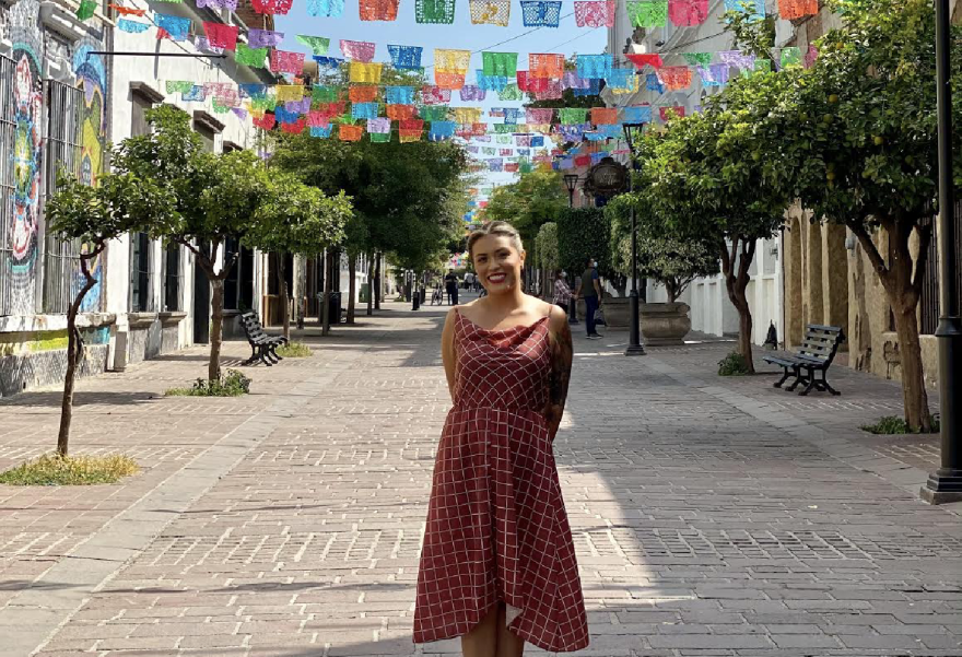 An image of the author, Flor Arellano, on a tree-lined brick street in Tlaquepaque, Mexico.