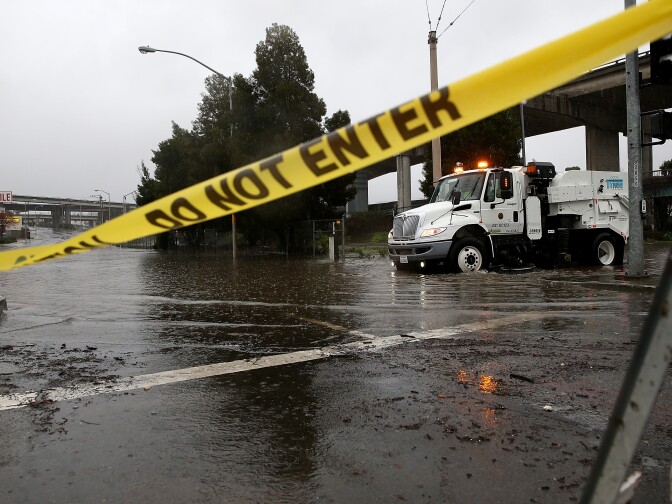 SAN FRANCISCO, CA - DECEMBER 11:  A San Francisco Department of Public Works street cleaner attempts to clear a drain that is causing an intersection to flood on December 11, 2014 in San Francisco, California. The San Francisco Bay Area is being hit with a severe storm that is bringing high winds and heavy rain that have toppled trees and caused local flooding.  (Photo by Justin Sullivan/Getty Images)