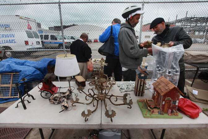 CHICAGO, IL - OCTOBER 14:  Shoppers look over items being offered for sale by a vendor at the century-old Maxwell Street Market on October 12, 2012 in Chicago, Illinois. The Supreme Court is scheduled to hear the case of   Kirtsaeng v. John Wiley & Sons this fall which will affect flea market vendors and their rights to sell things like electronics, books, artwork, furniture, as well as CDs and DVDs, without getting permission from the copyright holder of those products.  (Photo by Scott Olson/Getty Images)