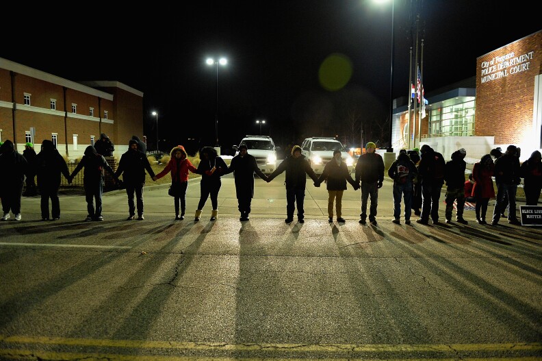 FERGUSON, MO -  MARCH 4: Protestors demonstrate outside the Ferguson Police Department in Ferguson, Missouri on March 4, 2015. The Federal Department of Justice decided today not to charge then Ferguson Police Officer, Darren Wilson, of any wrongdoing in the August shooting of Michael Brown Jr. The Department of Justice investigation did happen to find Ferguson Police Departments involvement in racially based policing. (Photo by Michael Thomas/Getty Images)