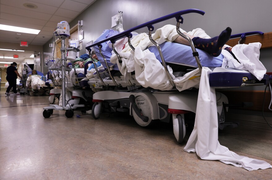 APPLE VALLEY, CALIFORNIA - JANUARY 05: Patients lie on stretchers in a hallway in the overloaded Emergency Room at Providence St. Mary Medical Center amid a surge in COVID-19 patients in Southern California on January 5, 2021 in Apple Valley, California. California has issued a new directive ordering hospitals with space to accept patients from other hospitals which have run out of ICU beds due to the coronavirus pandemic. The order could result in patients being shipped from Southern California to Northern California as Southern California continues to have zero percent of its remaining ICU (Intensive Care Unit) bed capacity. (Photo by Mario Tama/Getty Images)
