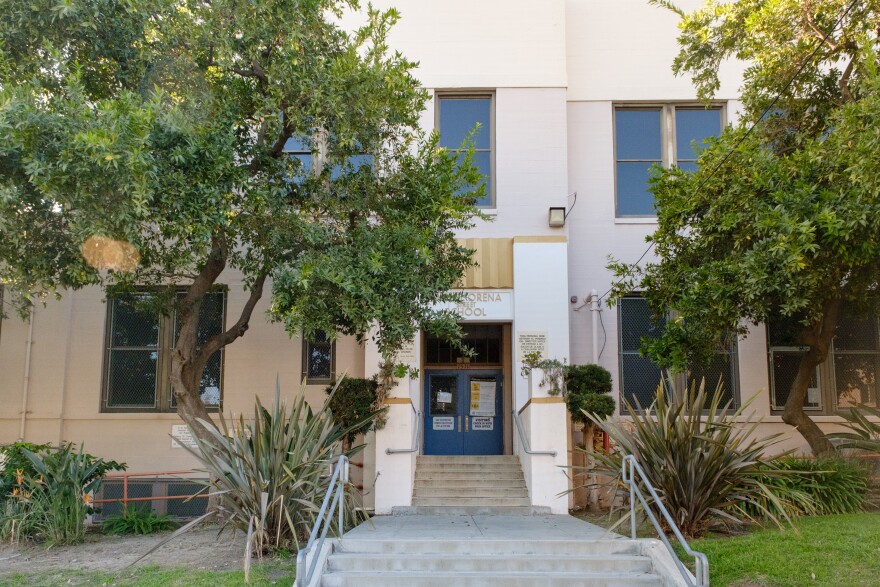 The exterior of a school with blue double doors.