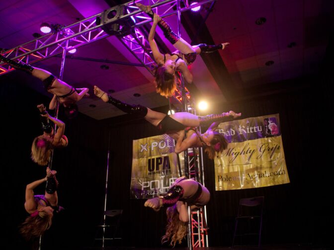 A synchronized pole dancing team performs on the main stage of the International Pole Dancing Convention at the Airport Marriot hotel on June 24, 2012.