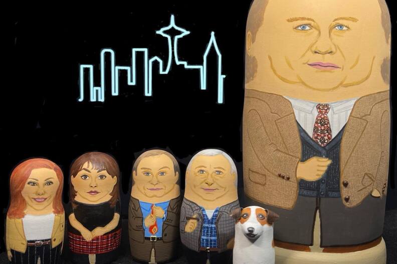 Russian doll version of characters from the TV show 'Frasier' are lined up in front of a black background that features the show's iconic cityscape outline.