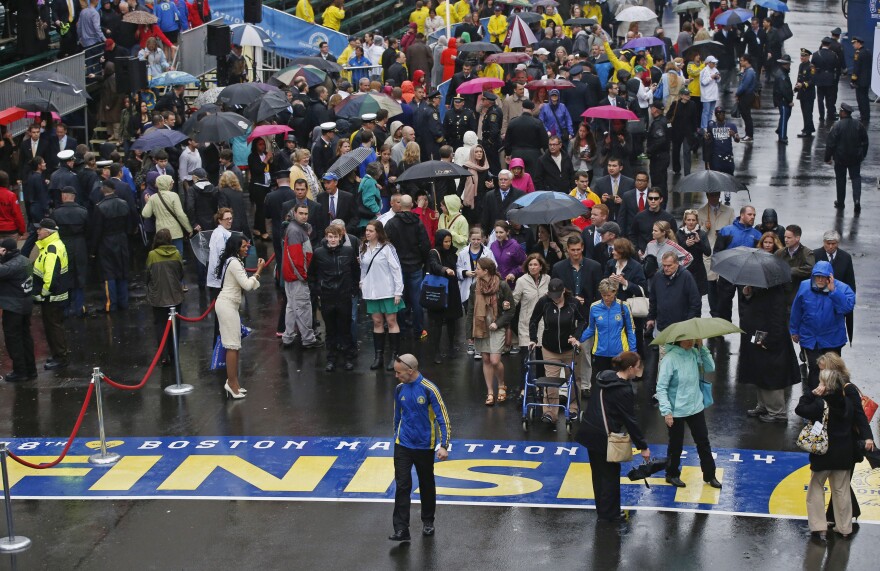 Family members, friends and survivors of the 2013 Boston Marathon bombing walk to the finish line after a remembrance ceremony on Boylston Street in Boston, Tuesday, April 15, 2014. (AP Photo/Elise Amendola)