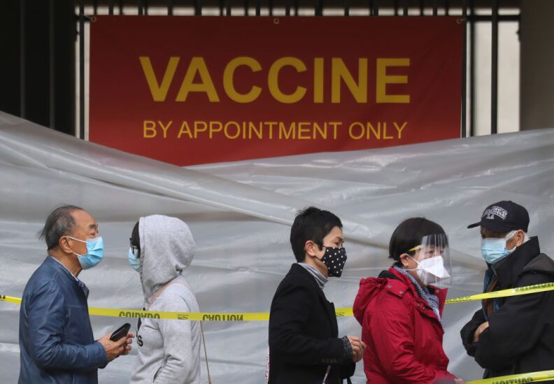 LOS ANGELES, CALIFORNIA - JANUARY 28: People with appointments stand in line to receive the COVID-19 vaccine at a vaccination site at Lincoln Park in East Los Angeles amid eased lockdown restrictions on January 28, 2021 in Los Angeles, California. The California Department of Public Health has announced an updated COVID-19 vaccine delivery plan as the state has faced mounting criticism over a slow coronavirus vaccine rollout. (Photo by Mario Tama/Getty Images)