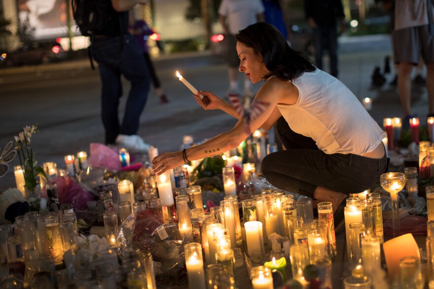 LAS VEGAS, NV - OCTOBER 4: Las Vegas resident Elisabeth Apcar lights candles at a makeshift memorial at the northern end of the Last Vegas Strip, October 4, 2017 in Las Vegas, Nevada. On October 1, Stephen Paddock killed at least 58 people and injured more than 450 after he opened fire on a large crowd at the Route 91 Harvest country music festival. The massacre is one of the deadliest mass shooting events in U.S. history. (Photo by Drew Angerer/Getty Images)
