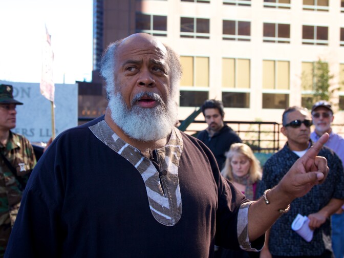 Kwazi Nkrumah, a community activist who co-founded Occupy the Hood Los Angeles, speaks to a crowd outside Mellon Bank about foreclosures.