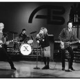 Black and white photo of four musicians playing on stage at American Bandstand.