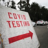 LOS ANGELES, CALIFORNIA - DECEMBER 07: Vehicles line up to enter a COVID-19 testing site at Dodger Stadium on the first day of new stay-at-home orders on December 7, 2020 in Los Angeles, California. Under state order, 33 million residents of California have entered into regional shutdowns in an attempt to contain the spread of the coronavirus as ICU capacity has dipped below 15 percent in most regions of the state. Barbershops, hair and nail salons, museums, zoos, movies theaters are closed while restaurants are open for takeout or delivery only. (Photo by Mario Tama/Getty Images)
