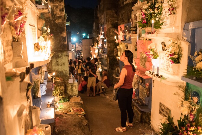 A woman looks at tombstones at a public cemetery on November 1, 2016 in Manila, Philippines.